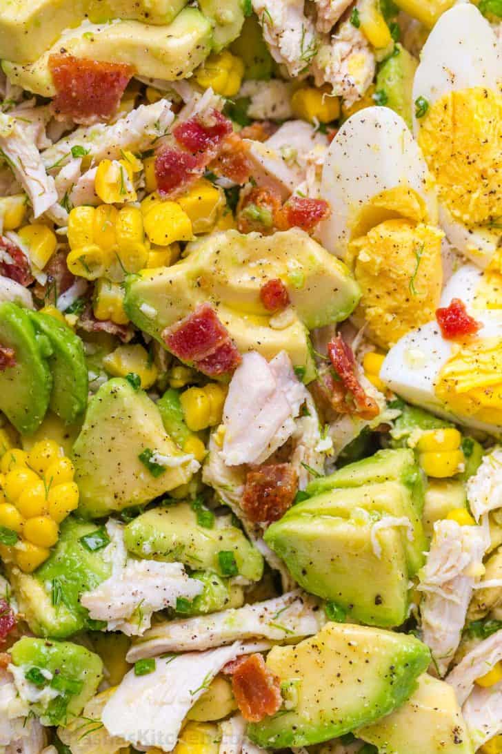 Avocado Chicken Salad served with hard-boiled eggs, corn, and crispy bacon